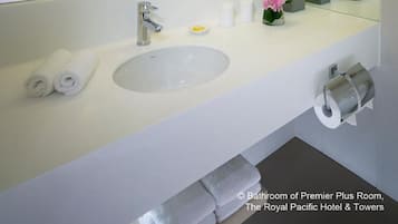 A modern bathroom with a large mirror, a white sink, and a glass shower enclosure.