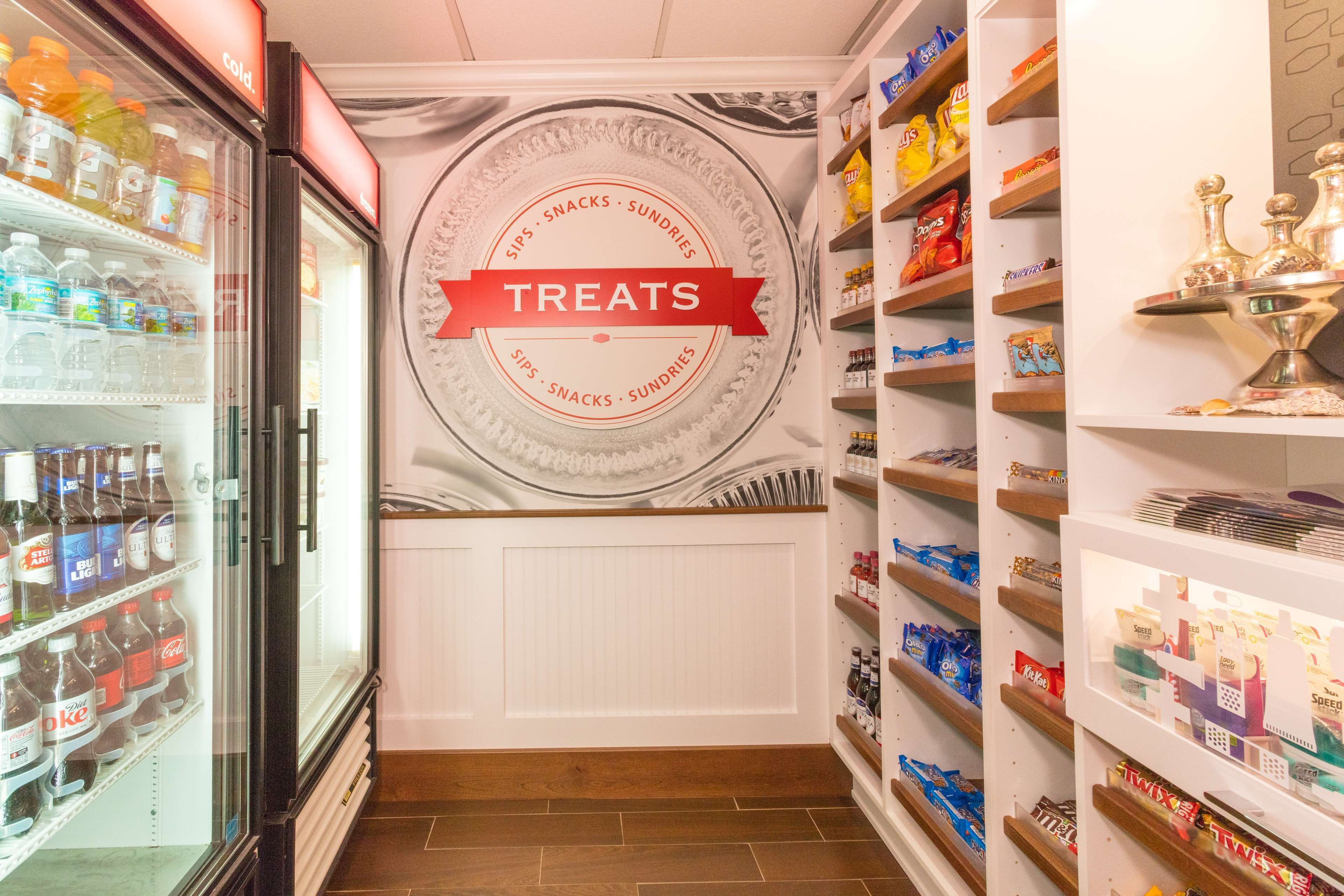 Ein Verkaufsbereich mit der Aufschrift 'TREATS', gefüllt mit Snacks und Getränken.