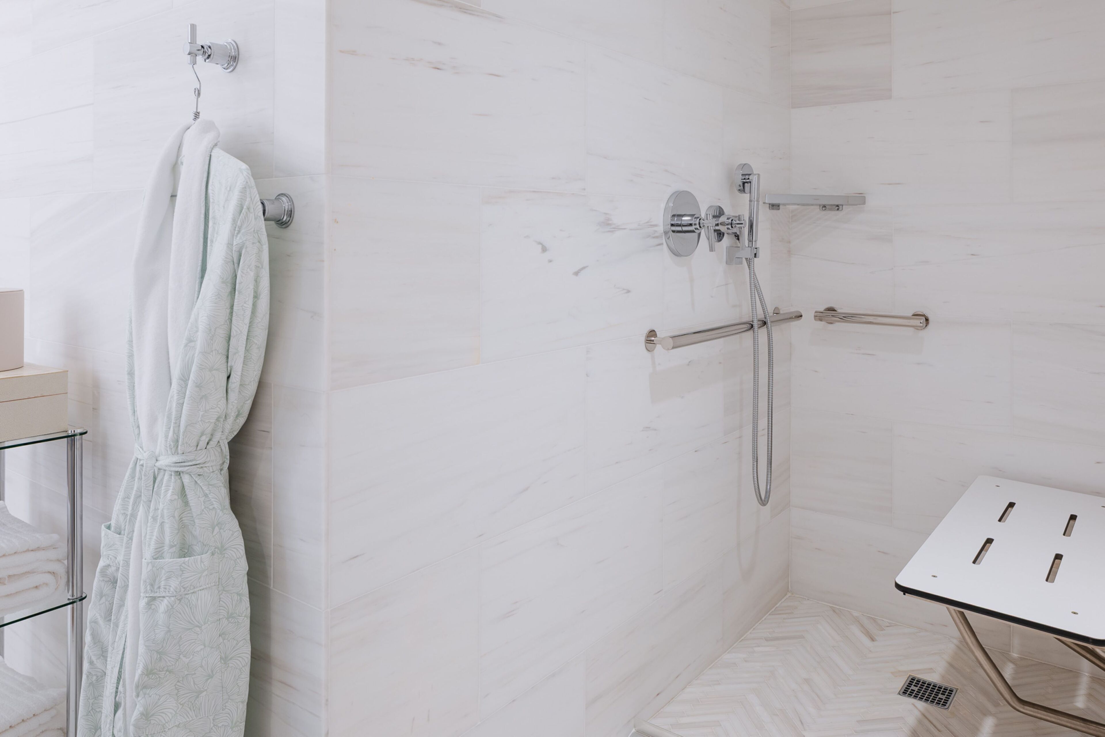 A modern bathroom with a shower, a towel rack, and a sink with a mirror.