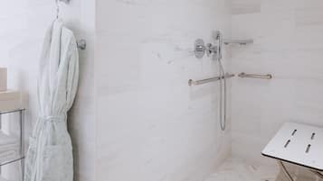 A modern bathroom with a shower, a towel rack, and a sink with a mirror.