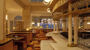 A high-end restaurant with a bar area, seating arrangements, and a view of the ocean. - Regent Santa Monica Beach by IHG (Santa Monica)