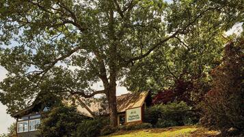 A building with a sign reading "Highlands Supper Club" surrounded by lush greenery.