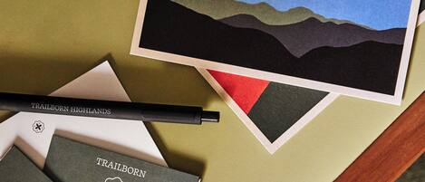 A table with a polaroid photo, a pen, and several room brochures for Trailborn Highlands.