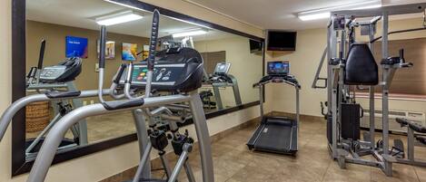A gym with treadmills, elliptical machines, and weight equipment.