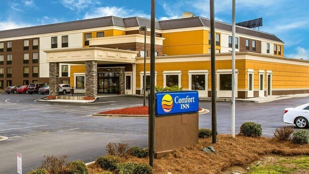 A Comfort Inn hotel with a modern design, featuring a central entrance, multiple floors, and a parking lot. - Comfort Inn Fort Mill Amusement Park at Carowinds Blvd (Fort Mill)