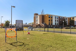 A grassy area with playground equipment, a building with a sign, and a fence. - Comfort Inn Fort Mill Amusement Park at Carowinds Blvd (Fort Mill)