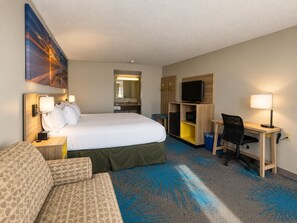 A hotel room with a bed, a desk, a chair, a television, and a bathroom. - Days Inn by Wyndham Hannibal (Hannibal)
