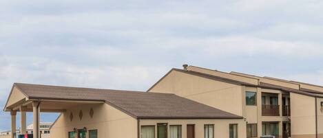 A motel with a covered entrance, a parking lot, and a two-story building with balconies.