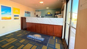 En reception med en marmorskiva, en skylt med texten ”Days Inn” och en välkomstmatta.