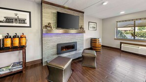 A modern living room with a fireplace, a mounted TV, and a window with a view.