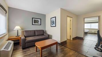 A modern living room with a sofa, a wooden coffee table, a lamp, and framed pictures on the wall.