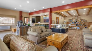 A spacious living area with a fireplace, comfortable seating, and a kitchen area with a bar. - Best Western Canyon De Chelly Inn (Chinle)