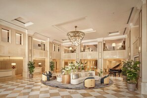 A spacious lobby with a checkered floor, a grand chandelier, and a piano. - Penha Longa Resort (Sintra)