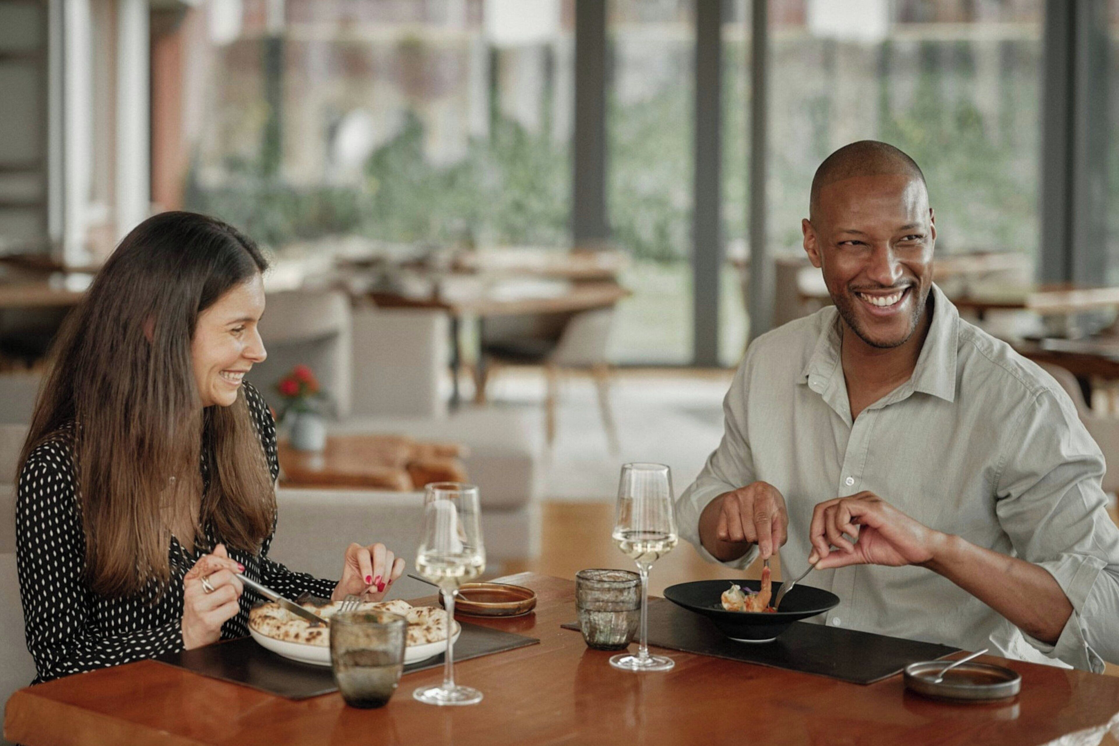 A dining table with plates, glasses, and cutlery.