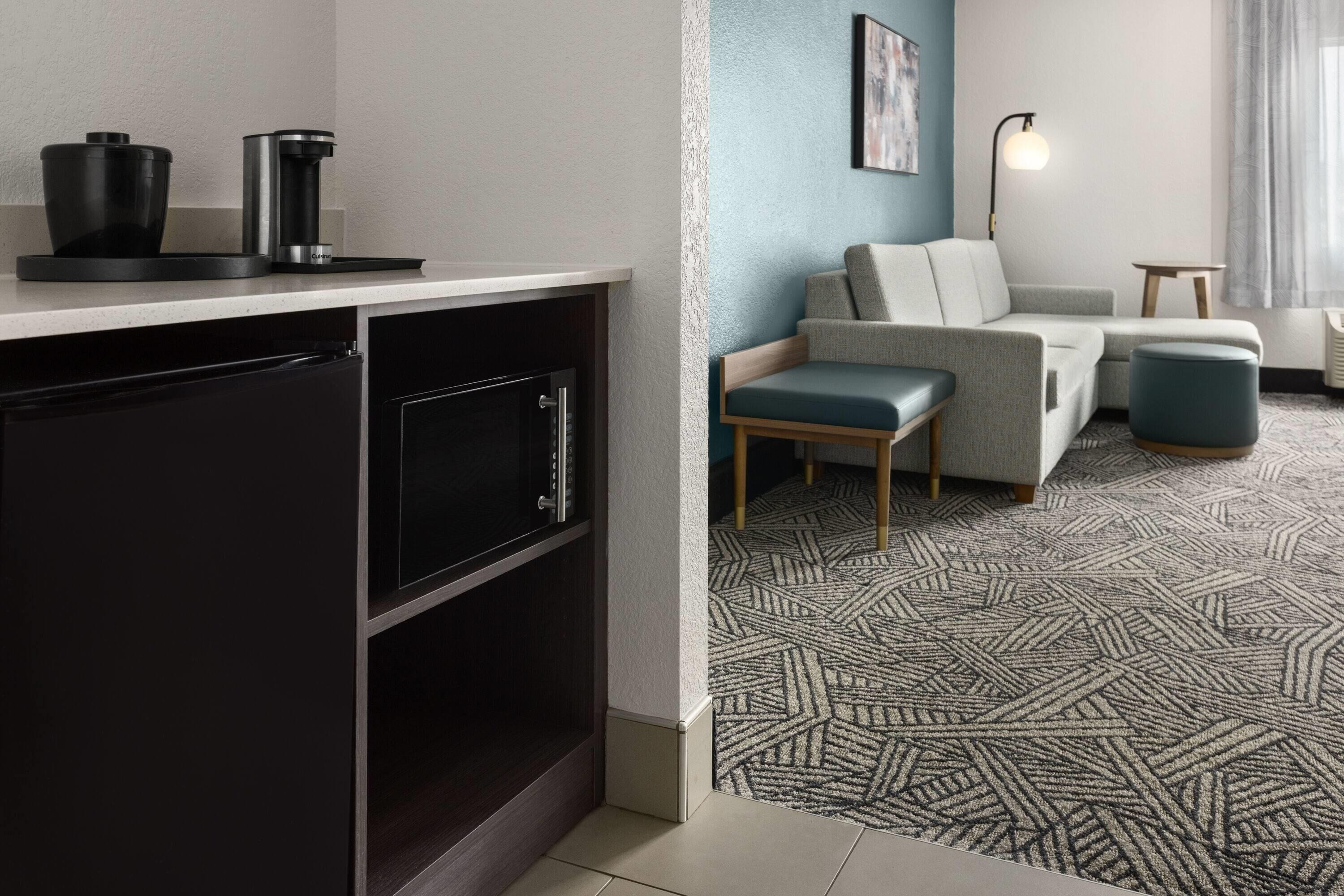 A modern kitchen with a dishwasher, a coffee maker, and a countertop.