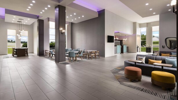 A spacious hotel lobby with a dining area, seating arrangements, and a view of the outdoors. - La Quinta Inn & Suites by Wyndham Chattanooga - East Ridge (Chattanooga)