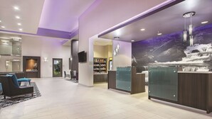 A hotel lobby with a reception desk, seating area, and a large mural of a waterfall. - La Quinta Inn & Suites by Wyndham Chattanooga - East Ridge (Chattanooga)