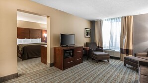 Una camera d'albergo con un letto, una TV, una scrivania e una sedia.