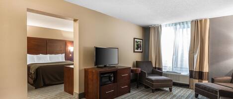Une chambre d’hôtel avec un lit, une télévision, un bureau et une chaise.