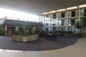 A spacious indoor area with a covered seating area, large windows, and a stone planter with plants.