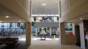A spacious lobby with a high ceiling, a central staircase, and a reception desk. - Days Inn by Wyndham Columbus Airport (Columbus)