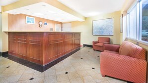 A reception area with a wooden desk, a clock, and a framed map on the wall. - Days Inn by Wyndham Arlington Pentagon (Arlington)
