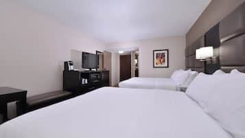 Habitación de hotel con dos camas, televisión, cafetera y un cuadro en la pared.