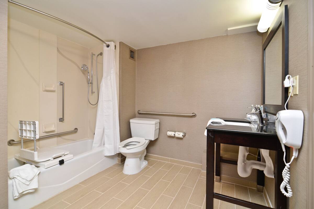 A bathroom with a shower, toilet, and sink.