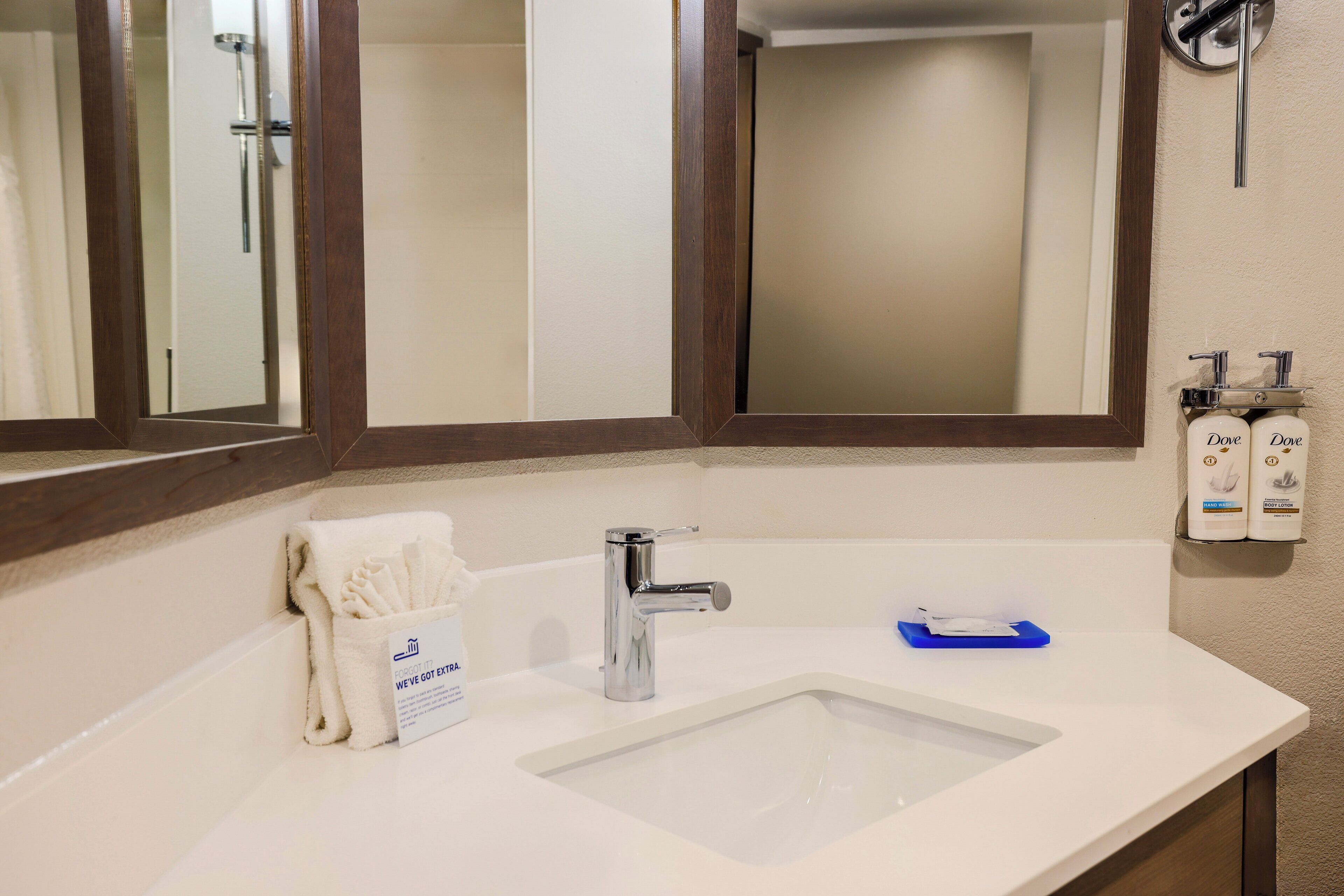 A bathroom with a white sink, a mirror, and a towel rack.