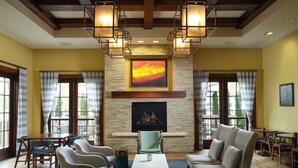 A spacious lobby with a fireplace, comfortable seating, and a modern chandelier. - Hotel Abrego (Monterey)