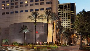 A multi-story hotel with a prominent 'Marriott' sign, featuring a modern architectural design with a large number of windows and a landscaped front area with palm trees and a well-maintained garden. - Marriott Miami Dadeland (Miami)