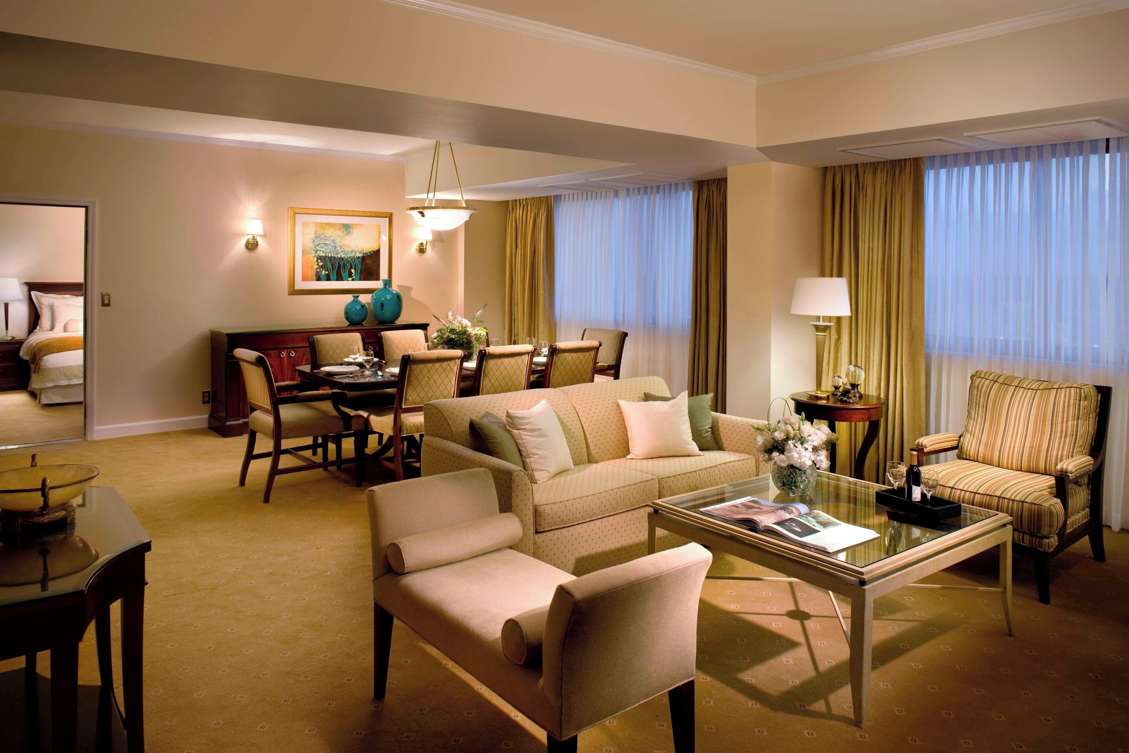 Ein Hotelzimmer mit Wohnbereich, Essbereich und einem separaten Schlafzimmer.