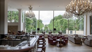 Amplia zona de estar con bar, asientos cómodos y ventanas grandes que ofrecen vistas al exterior.