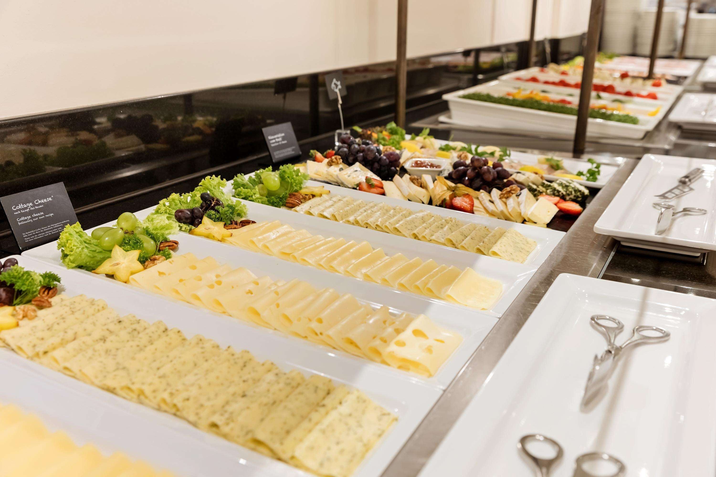 Un bufé con diversas opciones de queso y ensaladas.