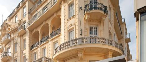 A multi-story hotel with a curved facade, balconies, and a sign reading "Parkhotel Schönbrunn".