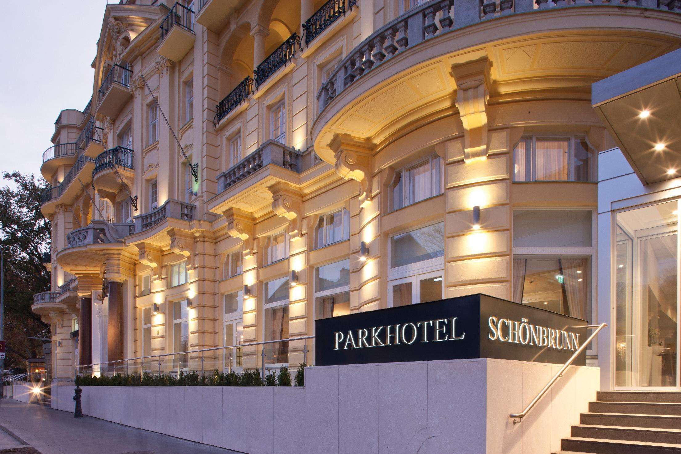 Une magnifique façade d’hôtel surmontée d’une enseigne indiquant « Parkhotel Schönbrunn ».