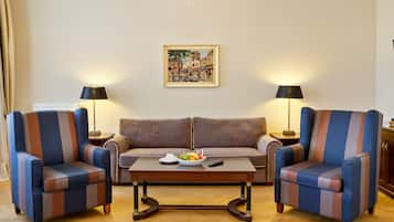 A living room with a sofa, two armchairs, a coffee table, and two lamps.