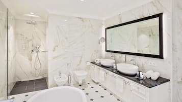 Ein modernes Badezimmer mit einem großen Spiegel, zwei Waschbecken, einer Badewanne und einer Duschkabine.