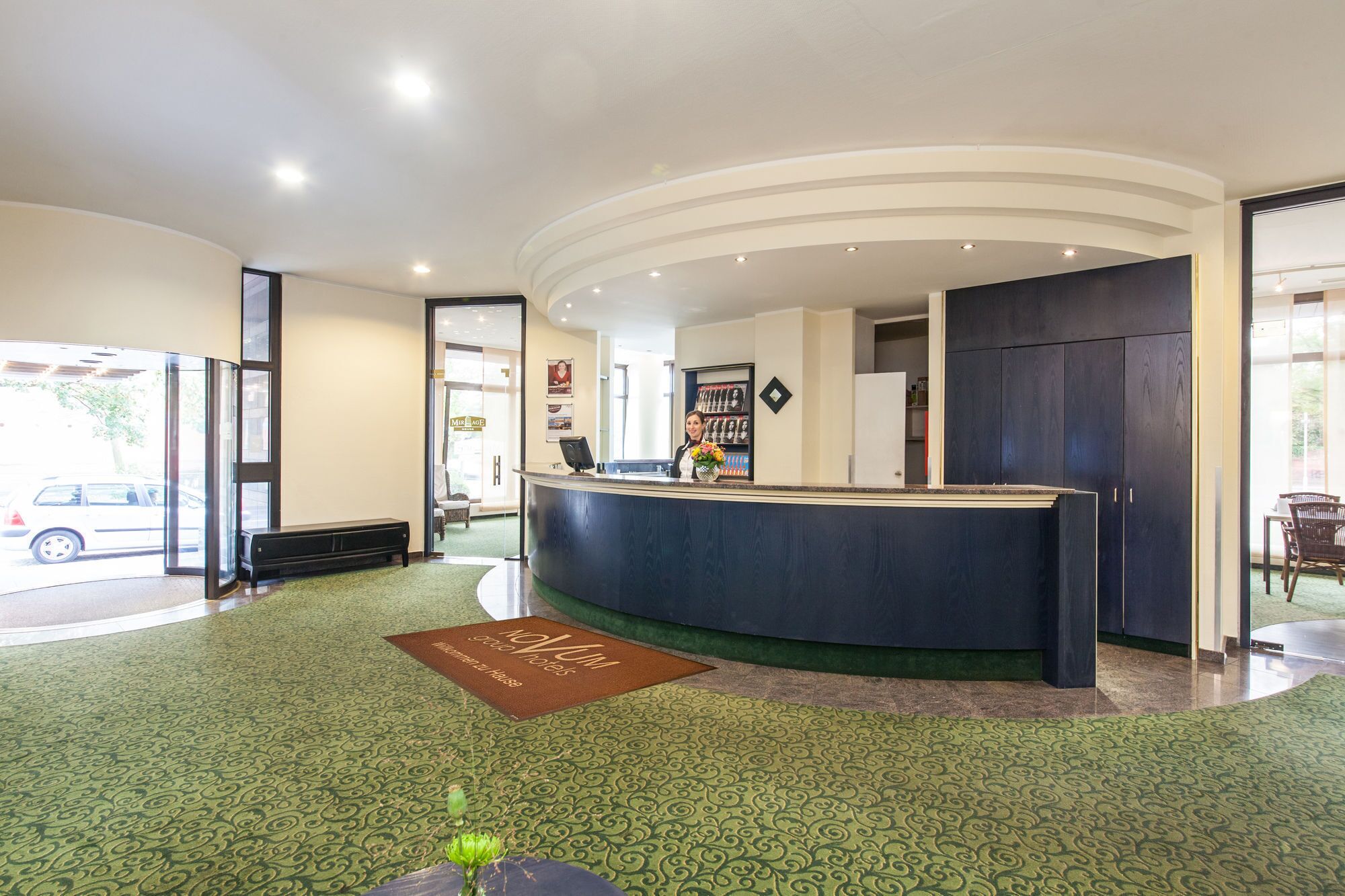 A hotel reception area with a curved reception desk, a bench, and a reception desk sign.