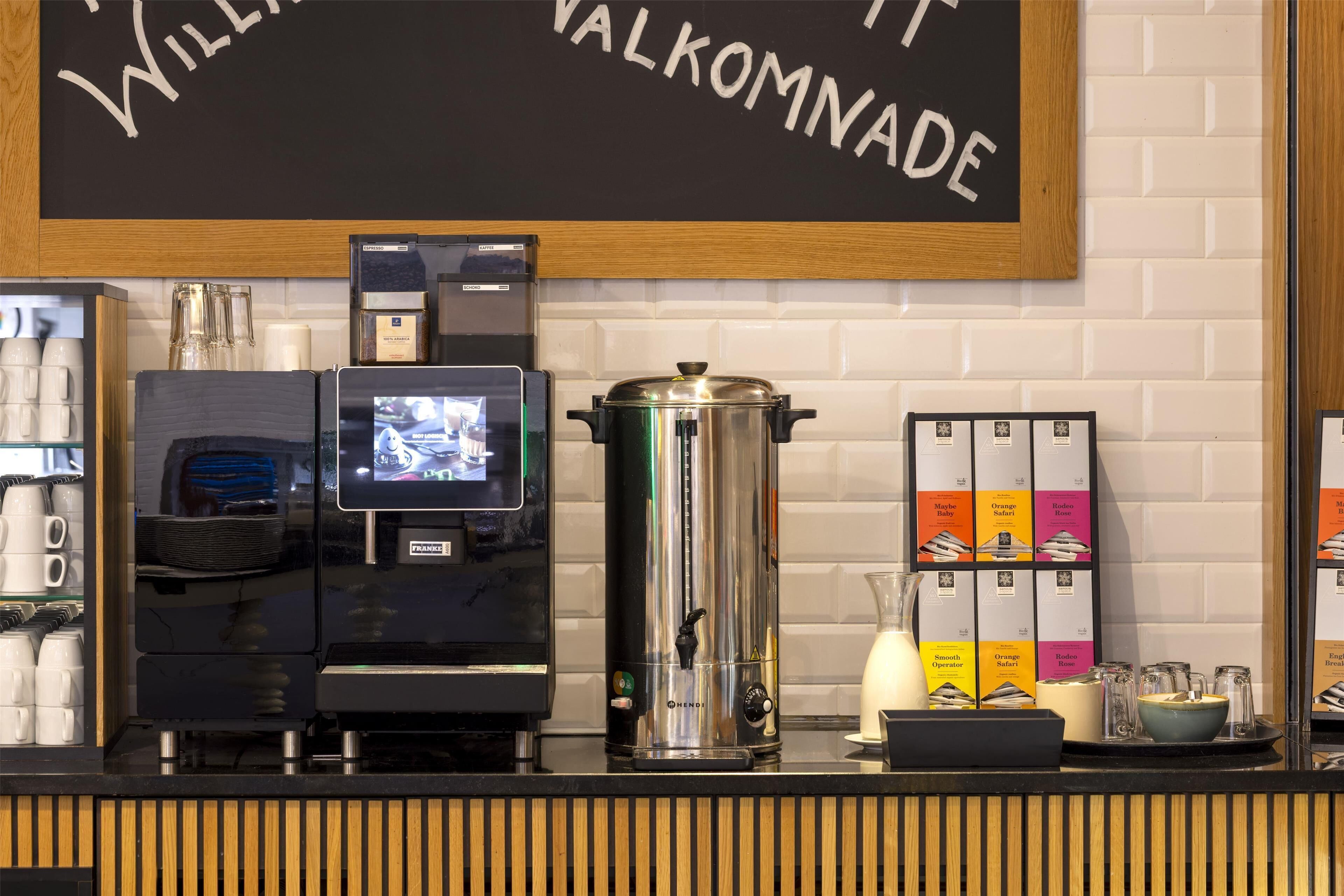 Una máquina de café con pantalla digital, un molinillo y un dispensador de agua sobre una encimera.