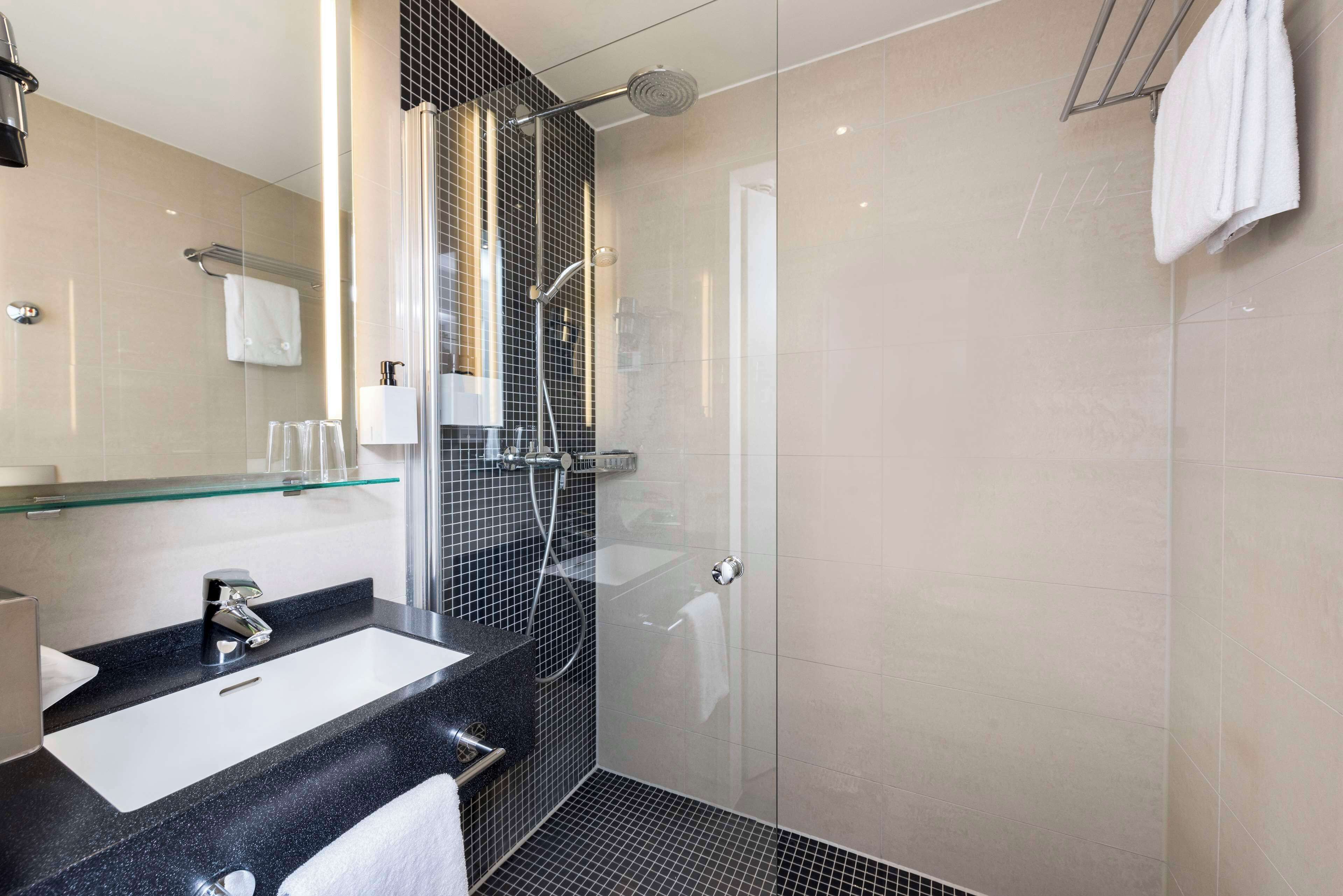standard single room | bathroom | shower, eco-friendly toiletries, hair dryer, towels