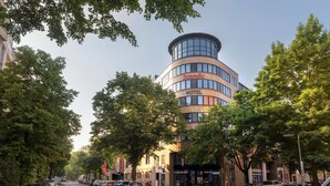 A modern hotel with a curved facade, large windows, and a prominent 'Scandic' sign. - Scandic Berlin Kurfürstendamm (Berlin)