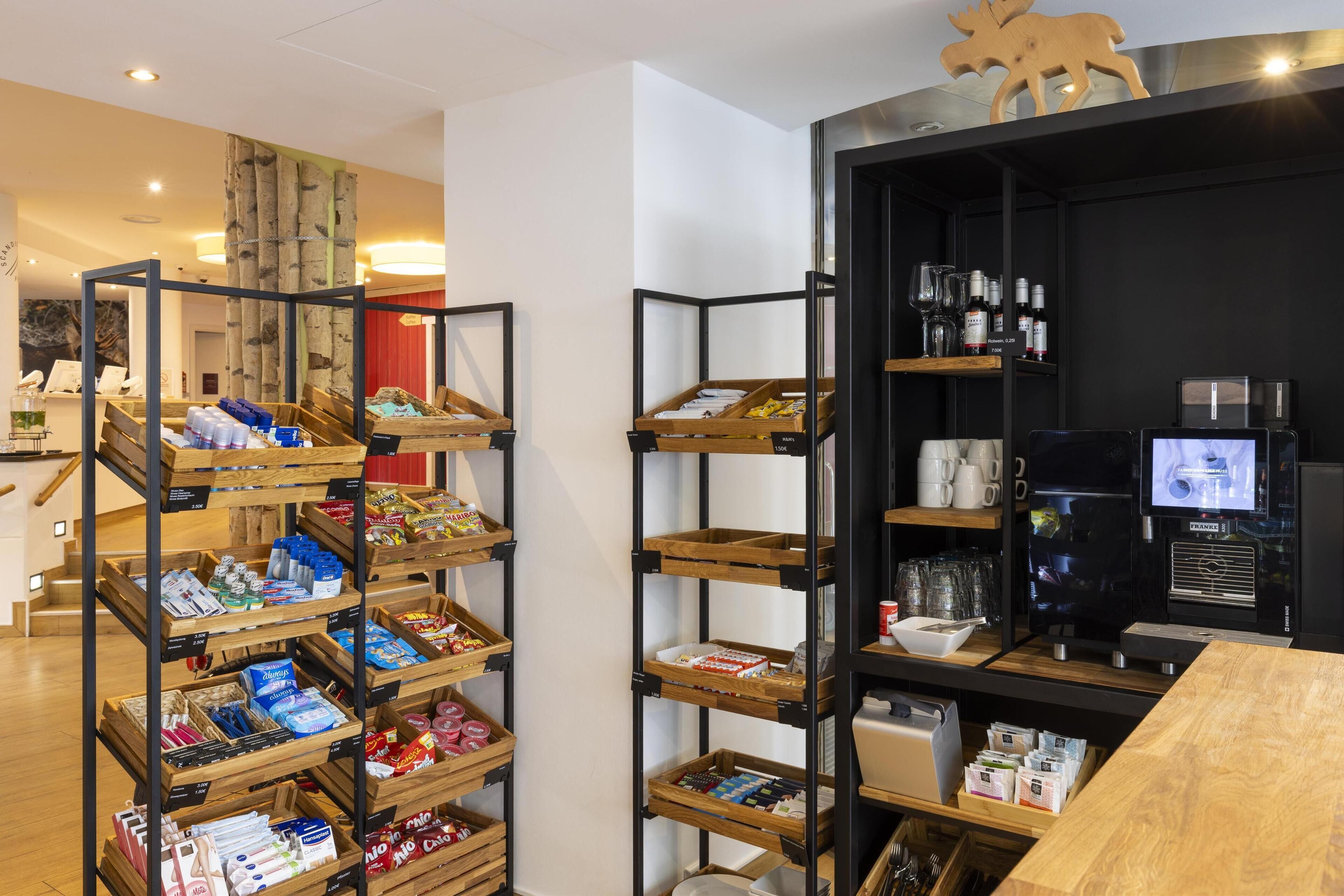 Eine moderne Hotelhalle mit Holzregalen und einer Kaffeestation.