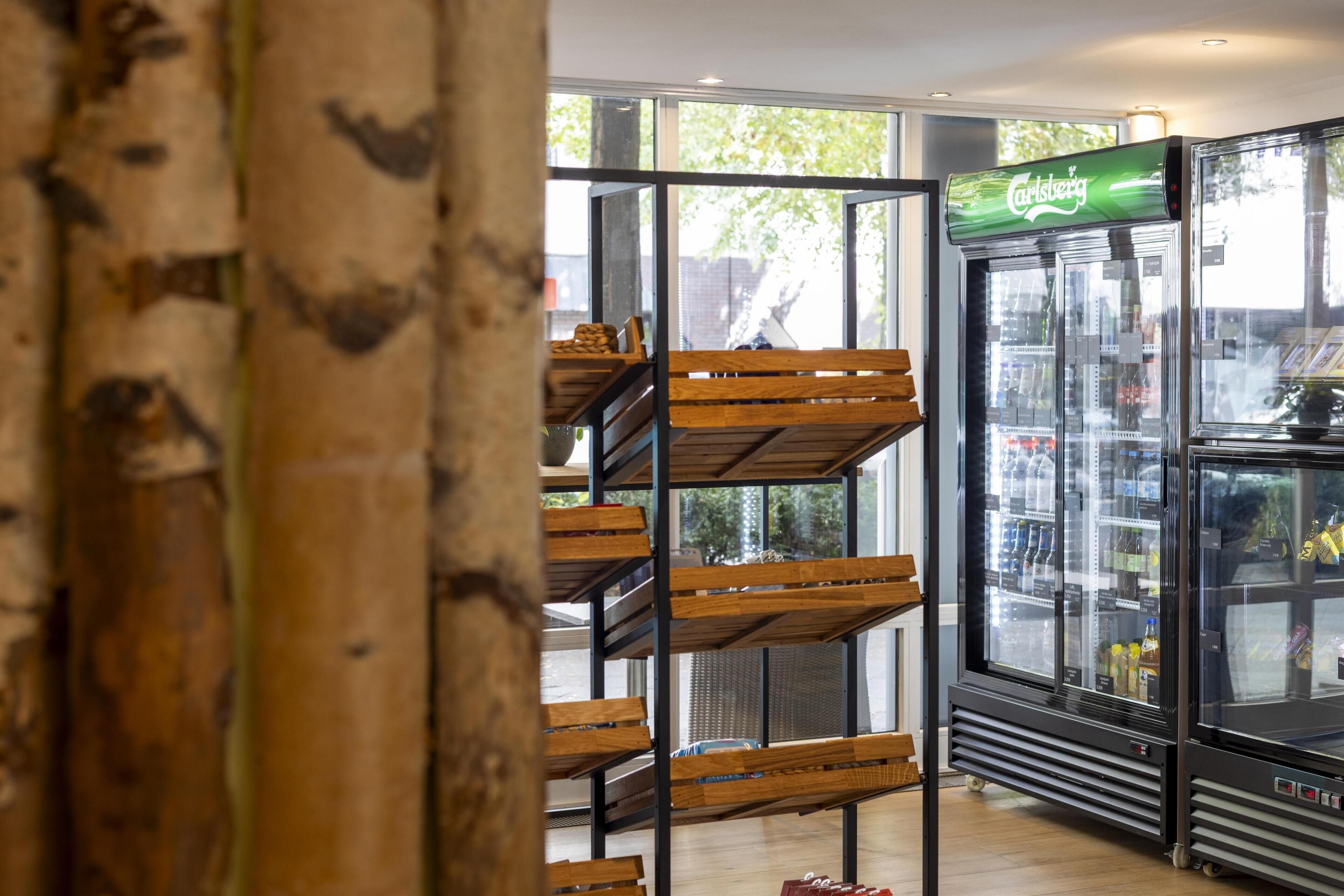 A modern interior with a glass-fronted beverage cooler and wooden shelves.