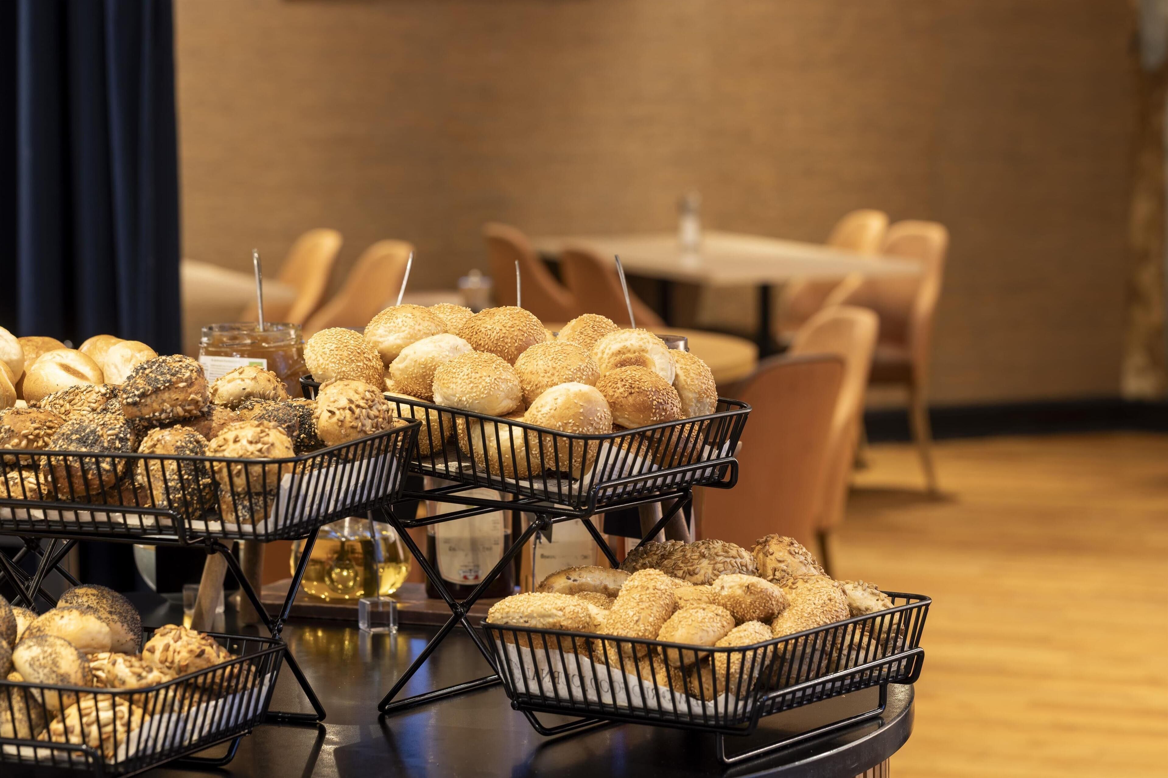 Ein Buffet mit verschiedenen Brotsorten und Gebäck in Drahtkörben.