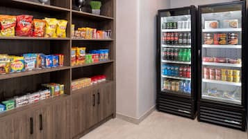 A snack and beverage vending area with multiple shelves stocked with various snacks and drinks.