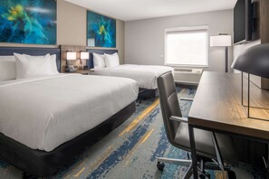 A hotel room with two beds, a desk, a chair, a TV, and artwork on the walls. - La Quinta Inn & Suites by Wyndham Spokane Downtown (Spokane)