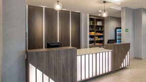 A reception desk with a modern design, featuring a wooden finish and integrated lighting. - La Quinta Inn & Suites by Wyndham Spokane Downtown (Spokane)