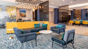 A modern hotel lobby with a seating area, a bar, and a reception desk. - La Quinta Inn & Suites by Wyndham Spokane Downtown (Spokane)