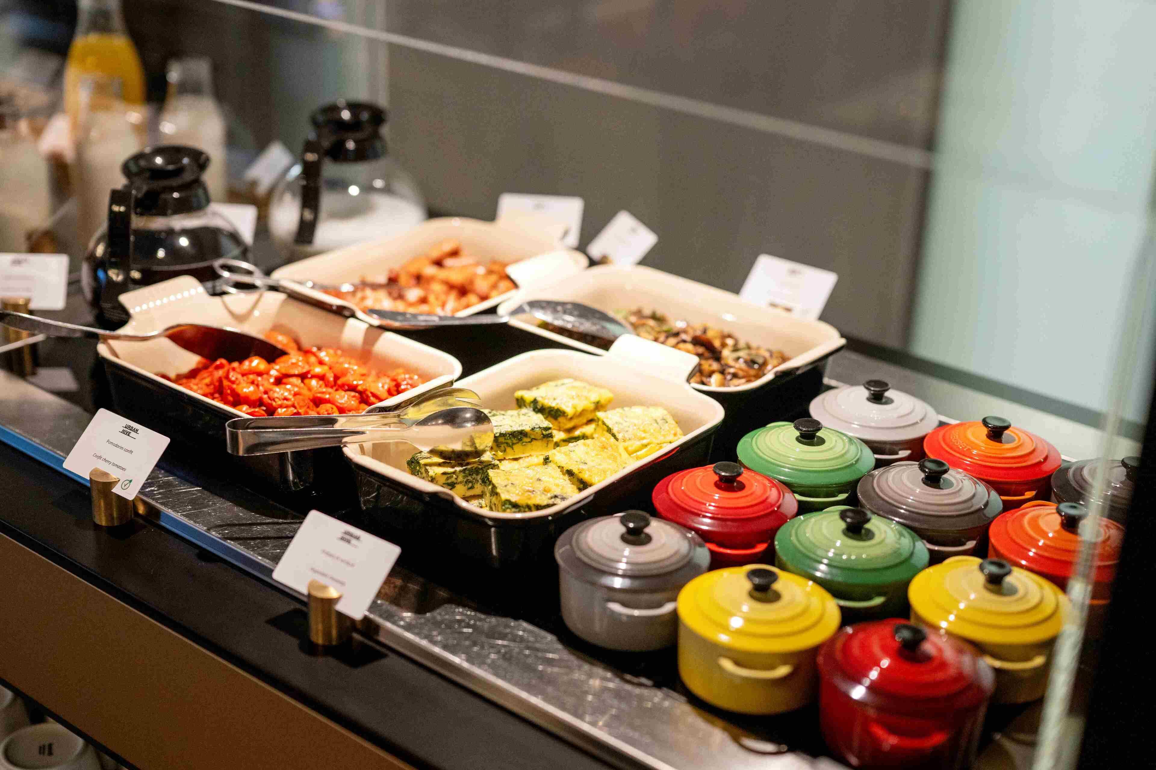 A buffet with various food items and condiments.